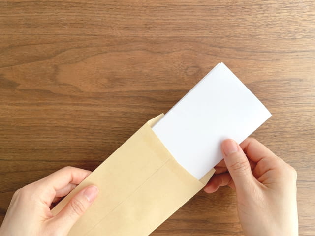 封筒に書類を入れる様子